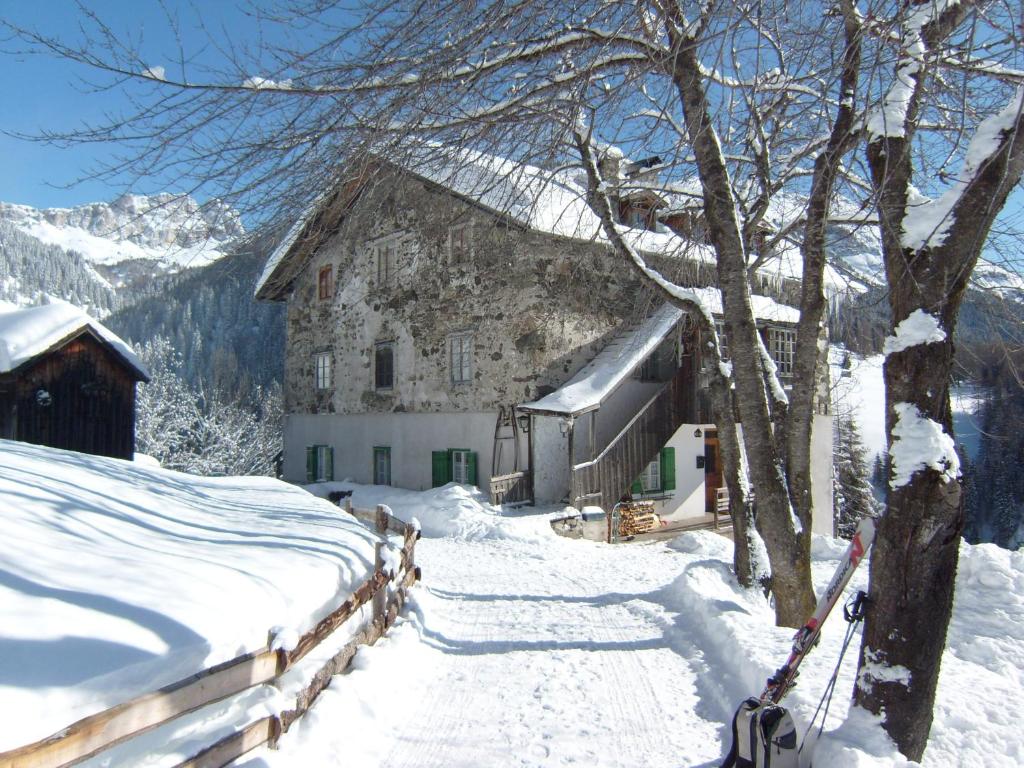 un edificio en la nieve junto a una valla en Cherz Romantic House, en Arabba