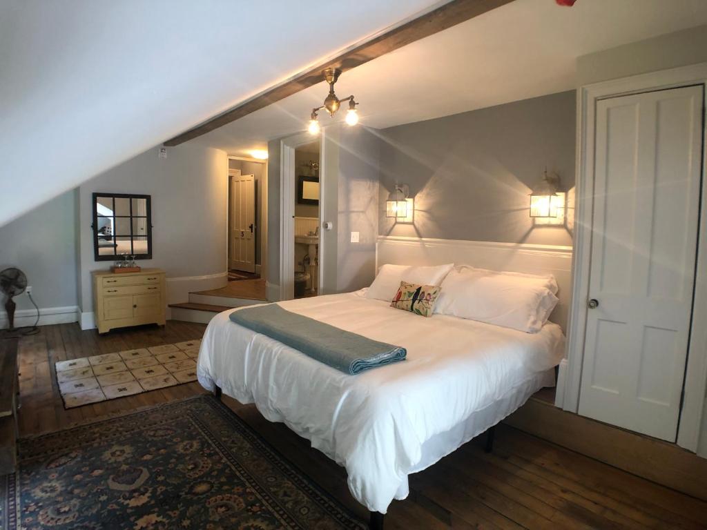 - une chambre dotée d'un grand lit avec des draps et des oreillers blancs dans l'établissement Mill Pond Inn, à Jefferson