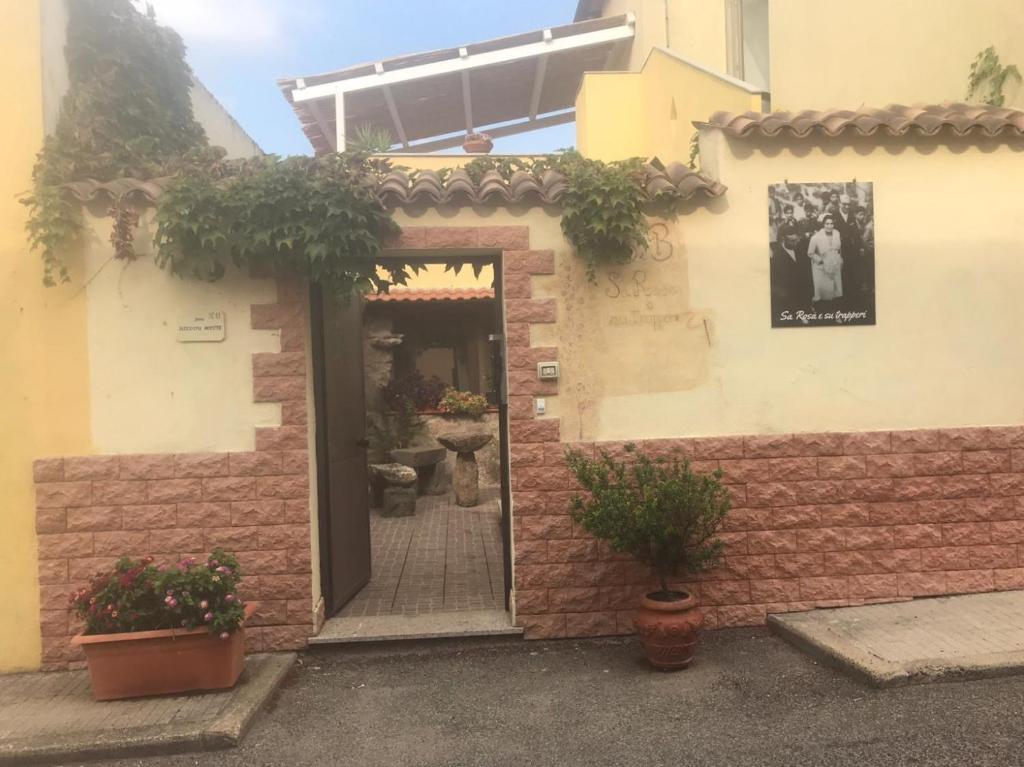 drzwi do budynku z roślinami w obiekcie Sa Rosa E Su Trapperi w mieście Oschiri