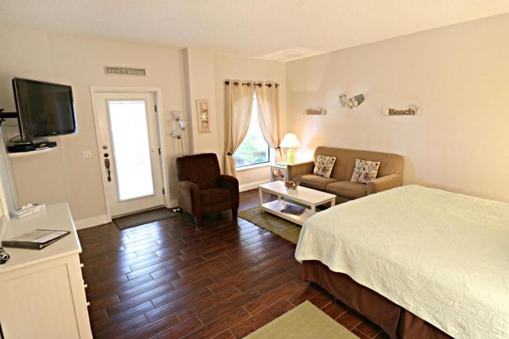 um quarto com uma cama, um sofá e uma televisão em Inn at Camachee Harbor Garden View 15 em Saint Augustine