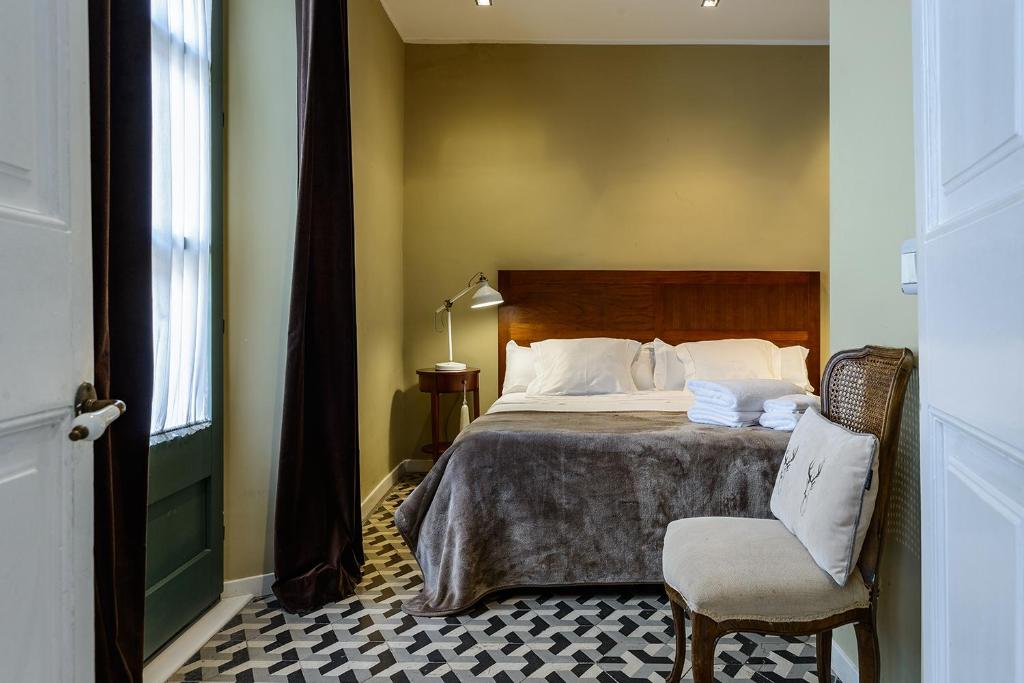 ジローナにあるAPG Espais Ramblaのベッドルーム1室(ベッド1台、椅子、窓付)