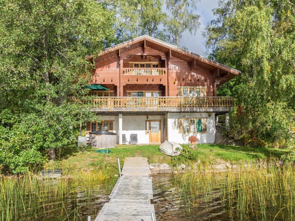 a wooden house on the water with a dock at Holiday Home Koivuranta by Interhome in Kylmälä