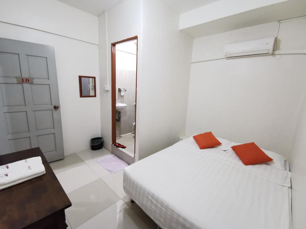 Habitación blanca con cama y espejo en Lodge88 ( l l ) en Ranau