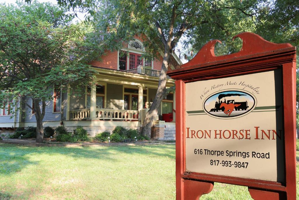 un cartello di Iron House Inn di fronte a una casa di Iron Horse Inn a Granbury
