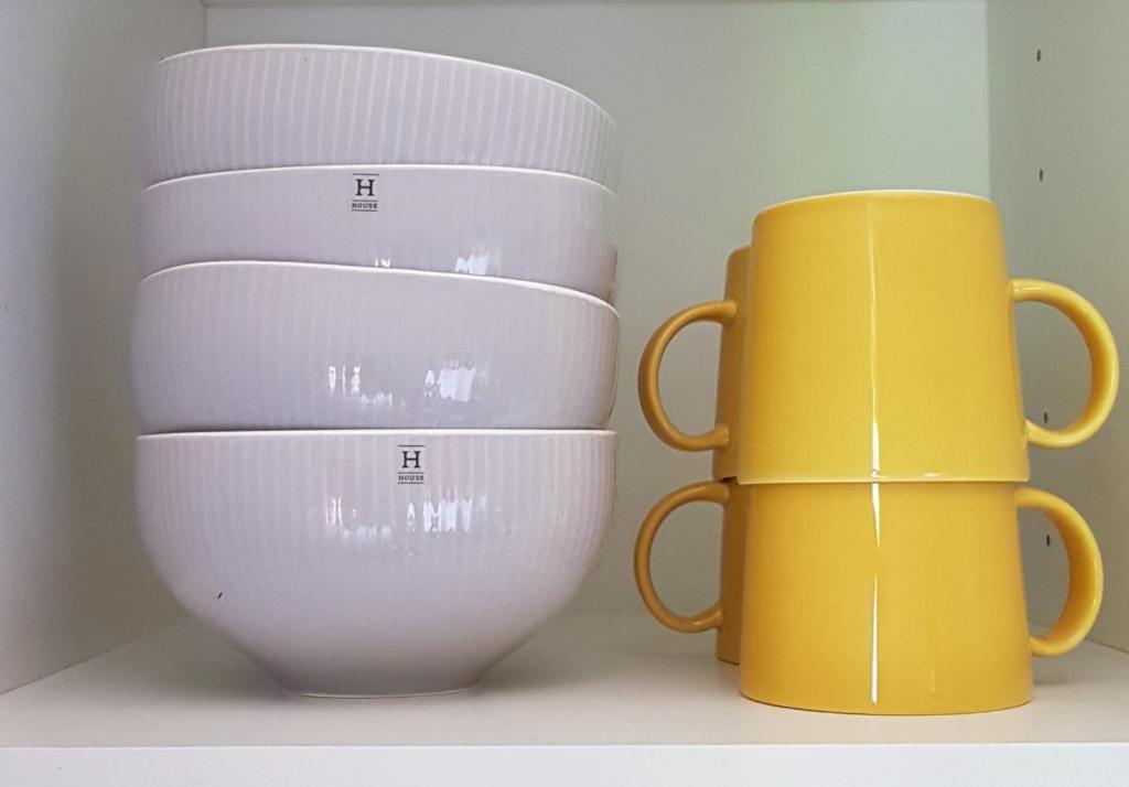 two mugs sitting next to each other on a shelf at Apartment Lintu in Mikkeli