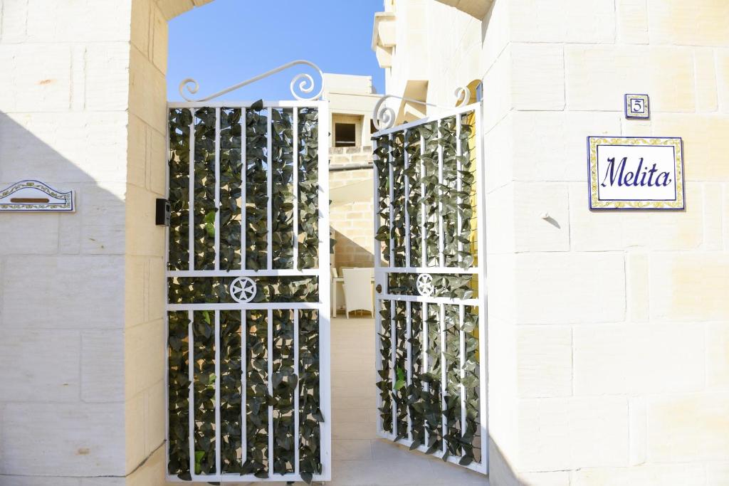 - une porte menant à un magasin de vin avec un bouquet de bouteilles de vin dans l'établissement Melita, à Ix-Xagħra