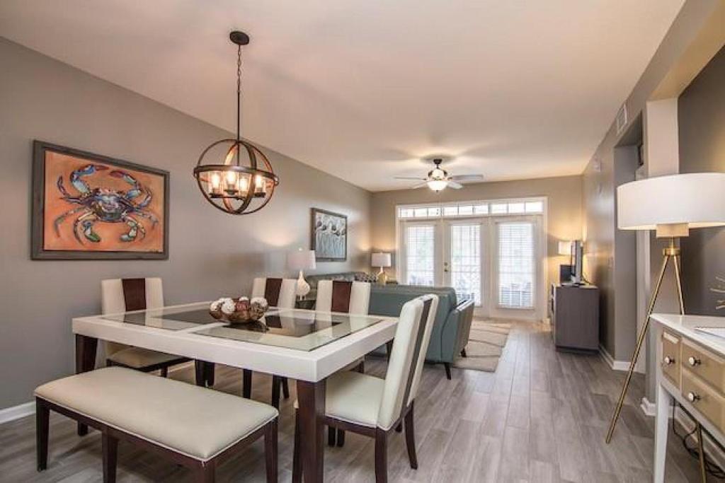 een eetkamer en woonkamer met een tafel en stoelen bij Seaside at Anastasia C202 in St. Augustine