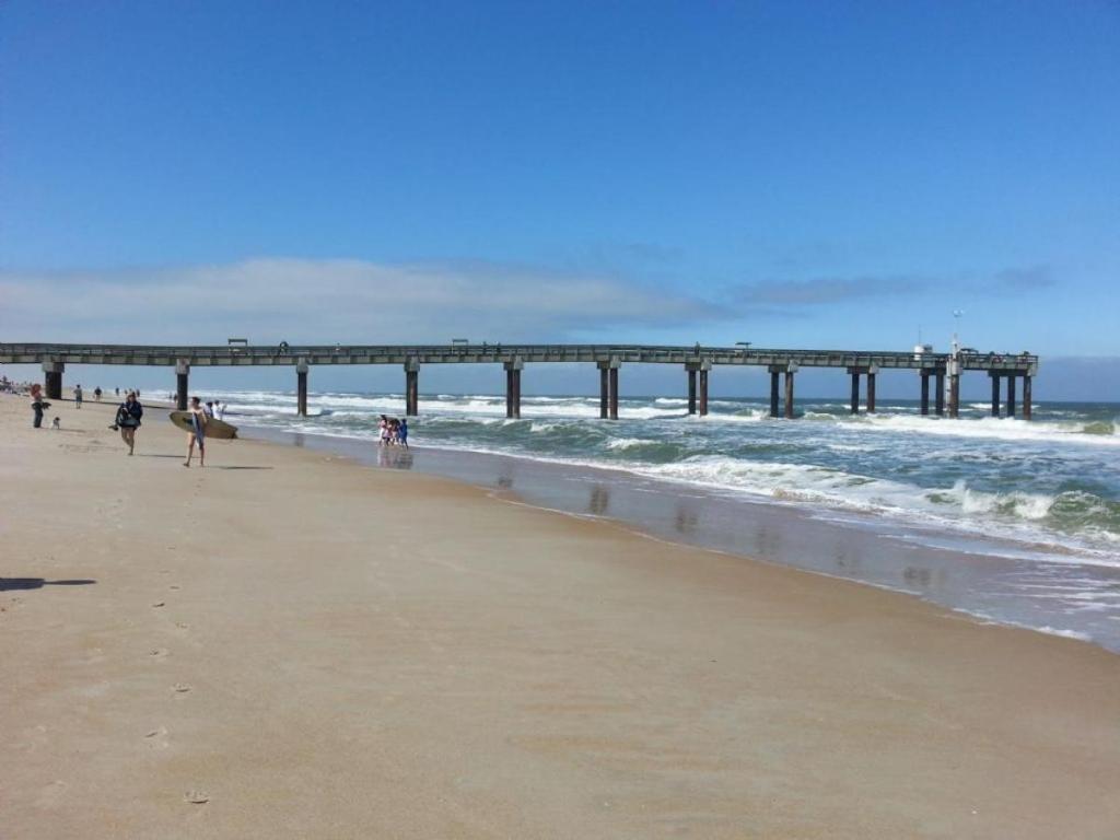 people walking on the beach near a pier at Seaside at Anastasia D205 in St. Augustine