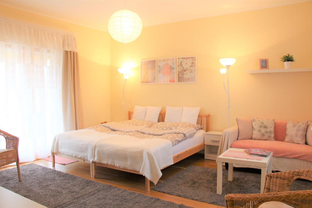 een slaapkamer met een bed en een bank bij Platán Vendégház in Csemő