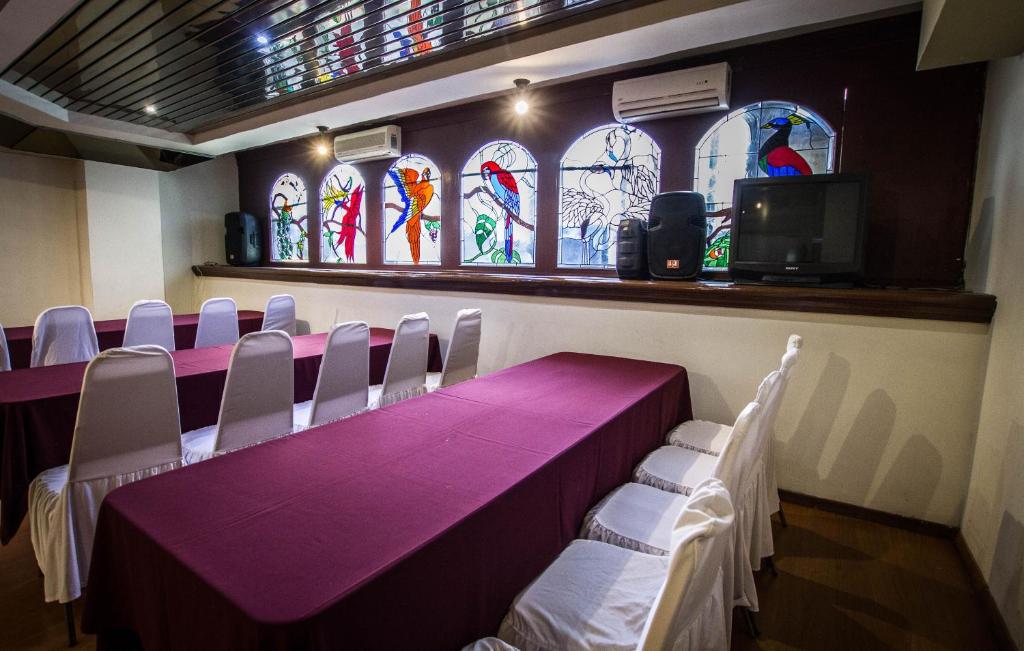 a room with a table and chairs and stained glass windows at Gilfer Hotel in Puebla