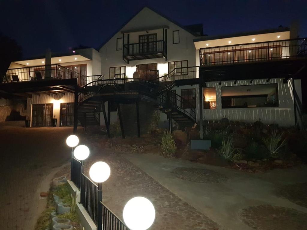 a large white house with lights in front of it at Bokamoso Views in Rustenburg