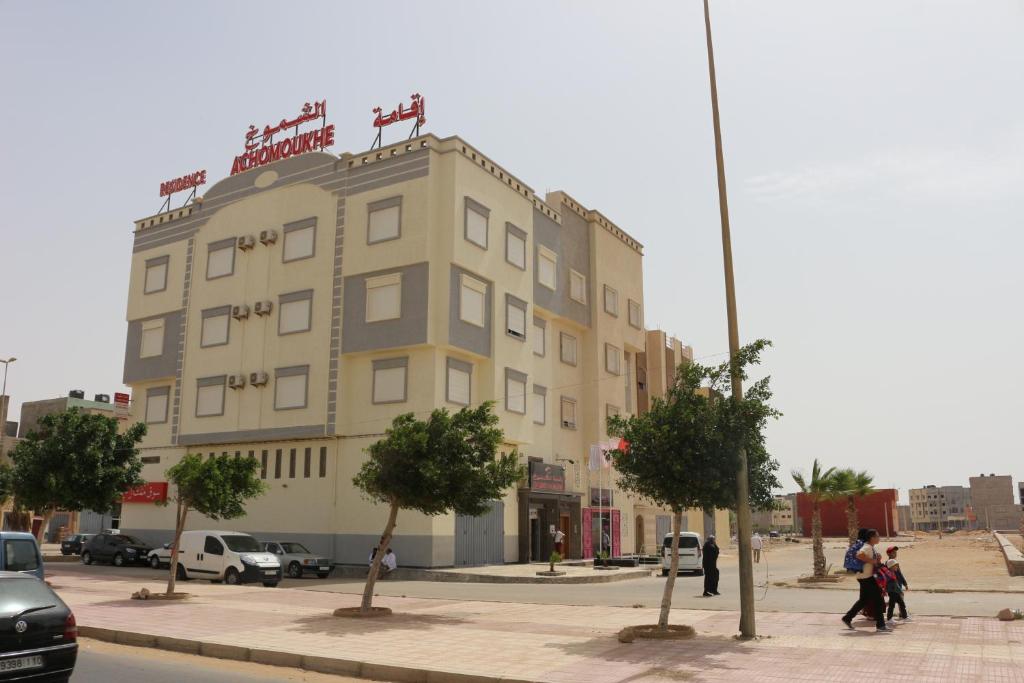 a building on a street with people walking in front of it at Residence Achomoukhe in Laayoune