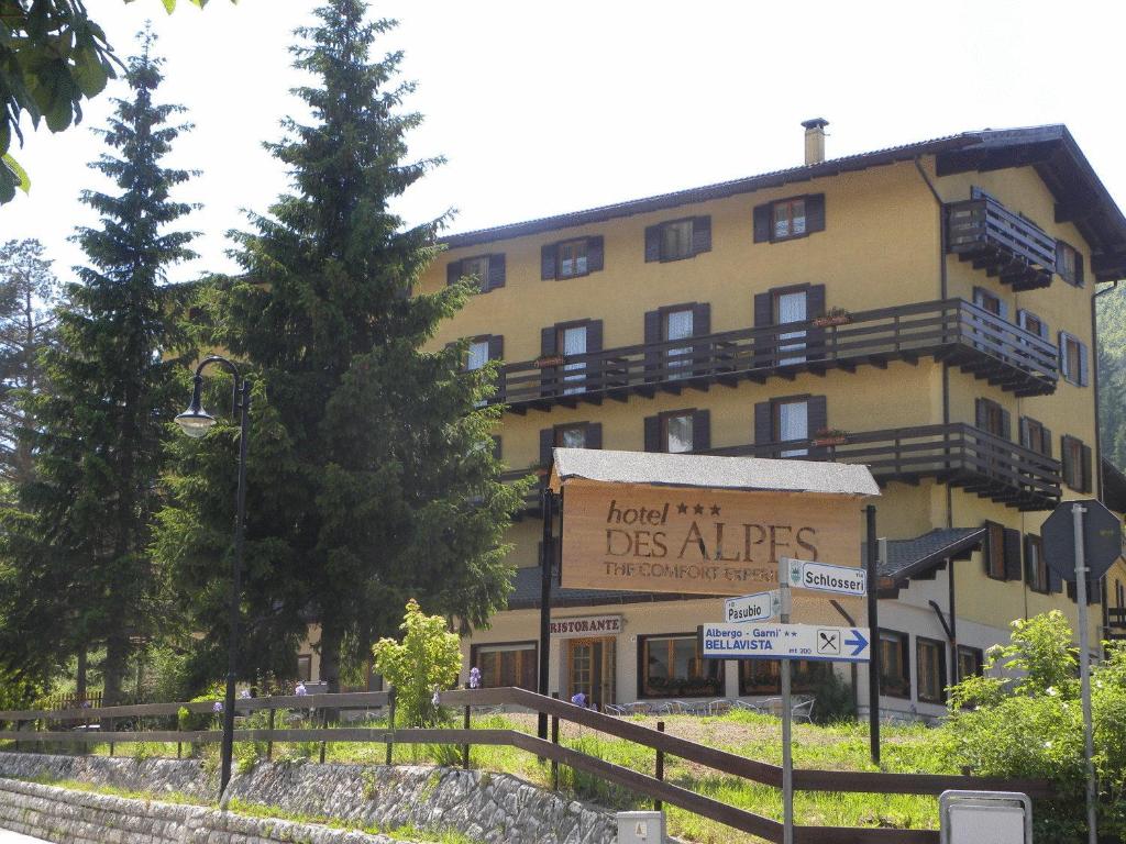 a large yellow building with a sign in front of it at Life Hotels Des Alpes in Folgaria