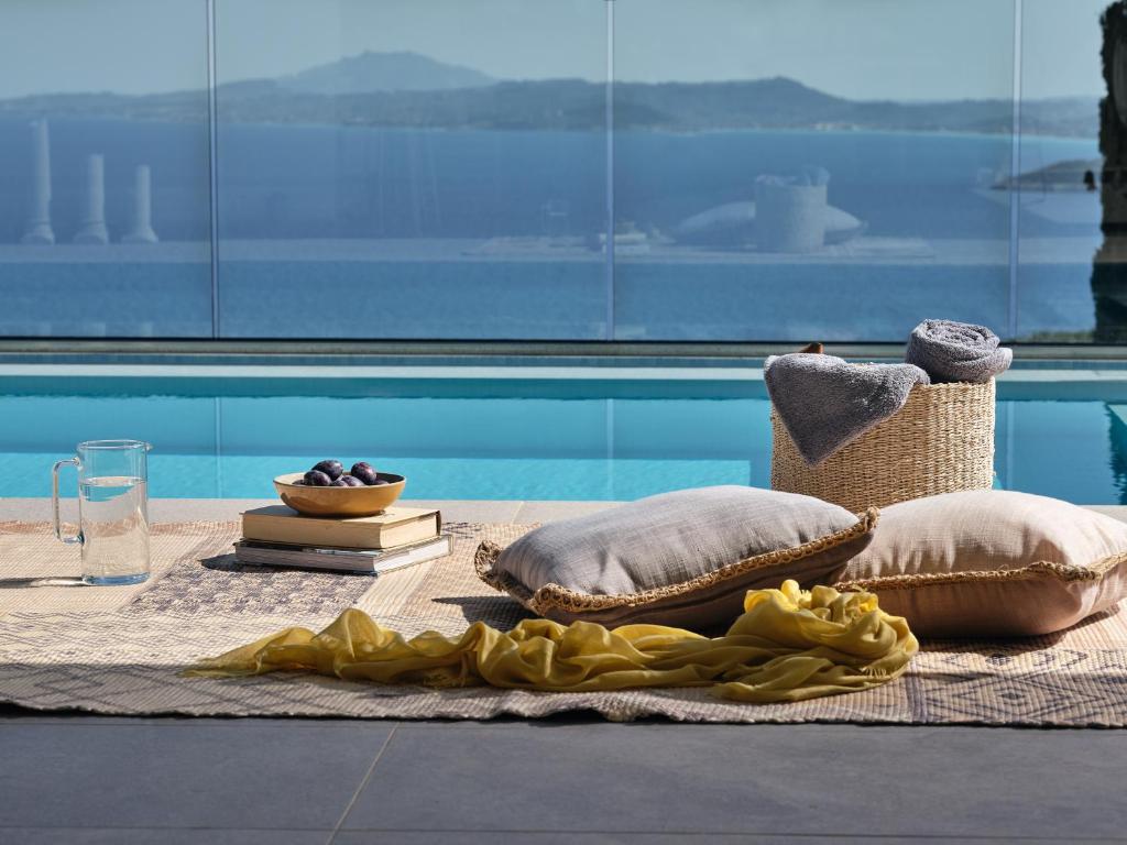 a blanket and pillows on a table next to a pool at Thea lux natur villa in Koríthion