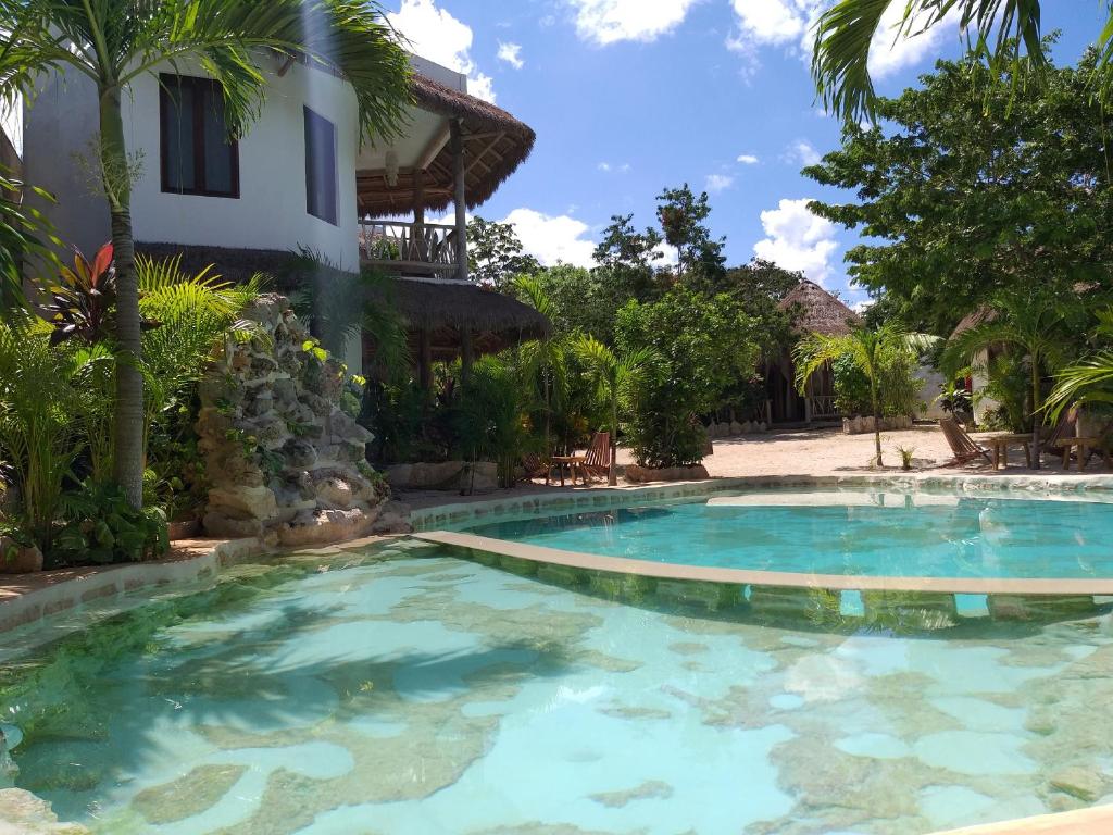 a swimming pool in front of a house at Aldea Balam in Tulum