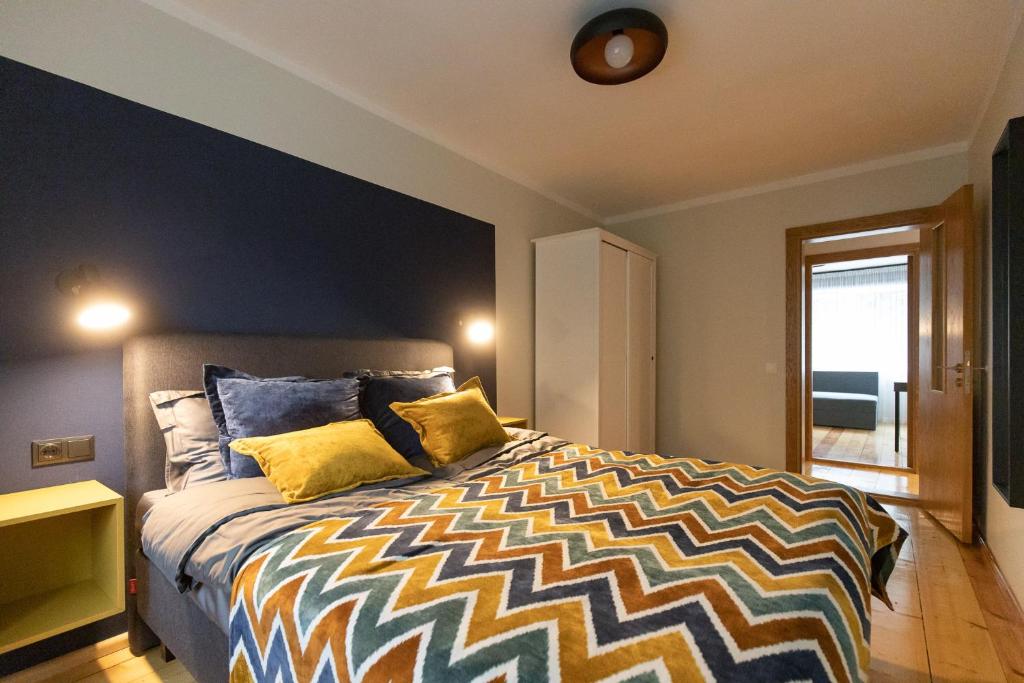 una camera da letto con un grande letto con cuscini gialli di City center Gauja apartment a Valmiera