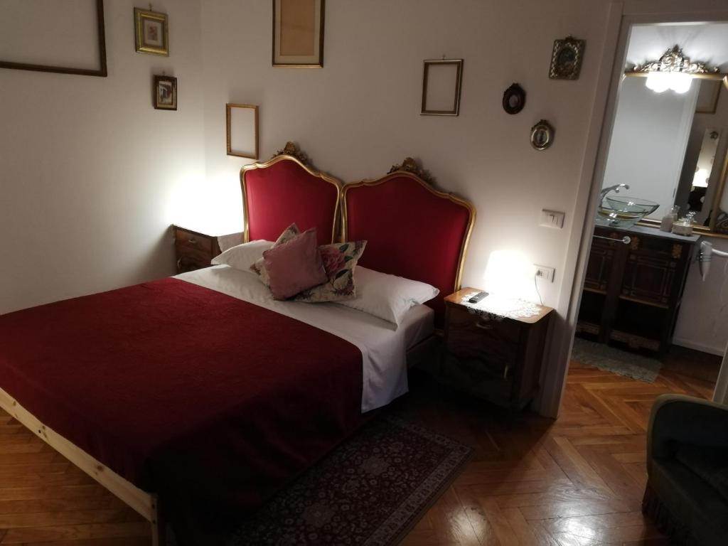 Schlafzimmer mit einem großen Bett mit einem roten Kopfteil in der Unterkunft Residenza Rubbiani - Fermata Fiera e Rizzoli in Bologna