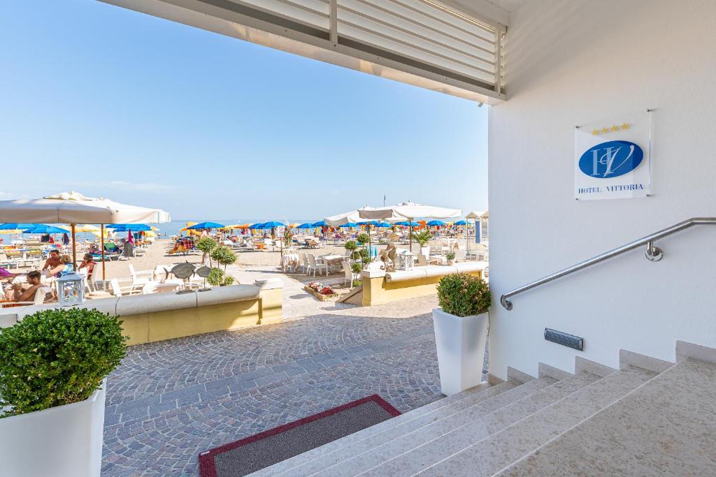Blick auf den Strand vom Gebäude eines Resorts in der Unterkunft Hotel Vittoria in Lignano Sabbiadoro