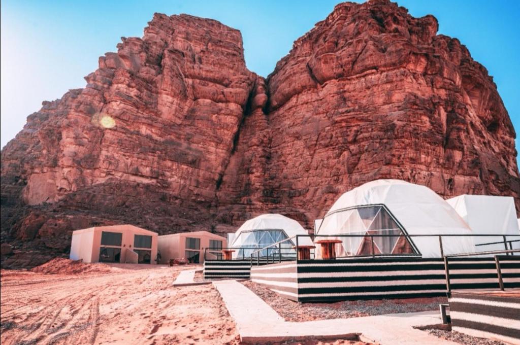 a group of domes in front of a mountain at Zeina Desert Lodge in Wadi Rum