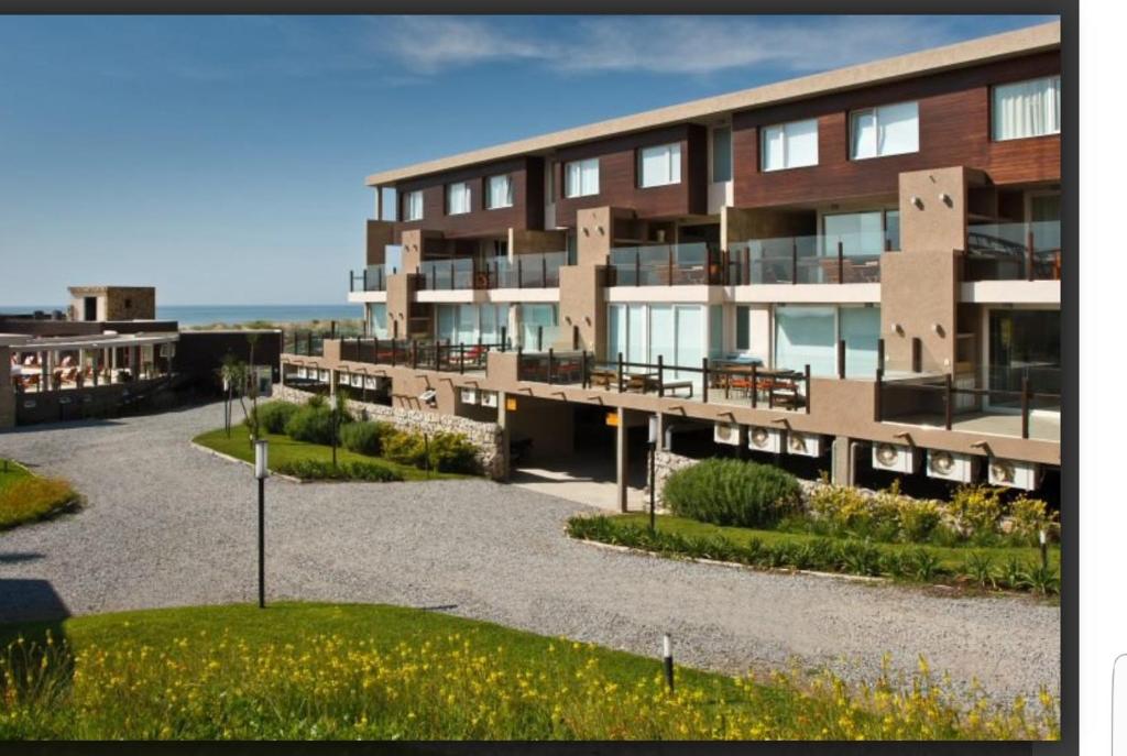 a large apartment building with a parking lot at Linda Bay Dúplex 221 in Mar de las Pampas
