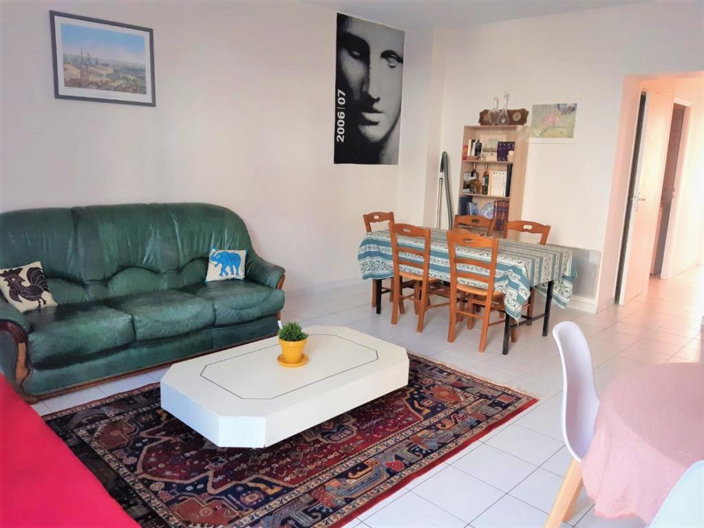 un soggiorno con divano verde e tavolo di Cœur de Ville a Rochefort