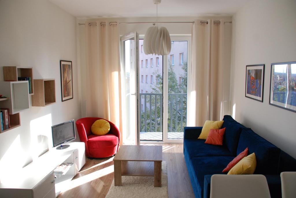 een woonkamer met een blauwe bank en een rode stoel bij SWING in Szczecin