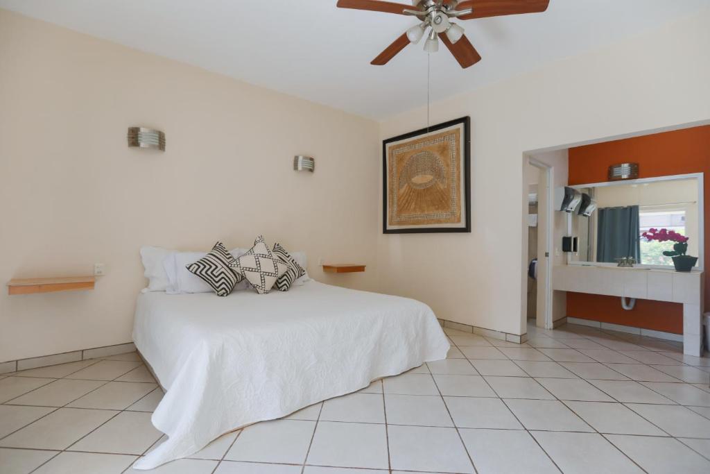 a bedroom with a white bed and a ceiling fan at Habitaciones Lucero 2 in Santa María del Oro