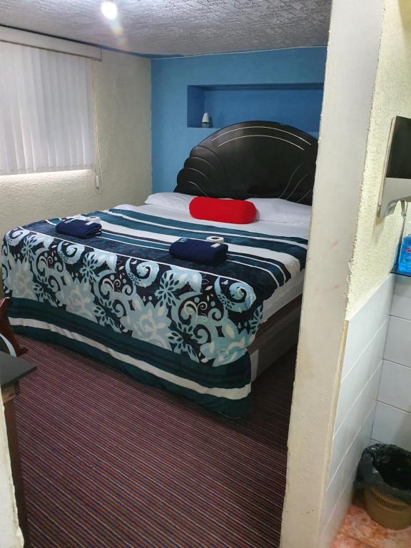 uma pequena cama num quarto com paredes azuis em hotel kasa kamelot 2 em Quetzaltenango