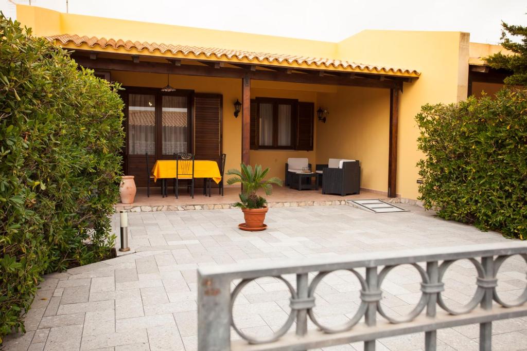a house with a patio with a yellow table and chairs at AROMA GARDEN in San Vito lo Capo