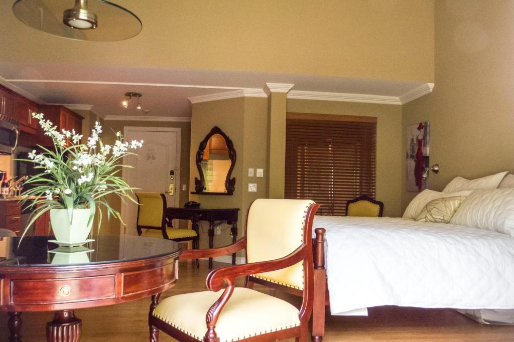 1 dormitorio con 1 cama, mesa y sillas en Studio-hôtel Villegiature Saint-Sauveur, en Piedmont