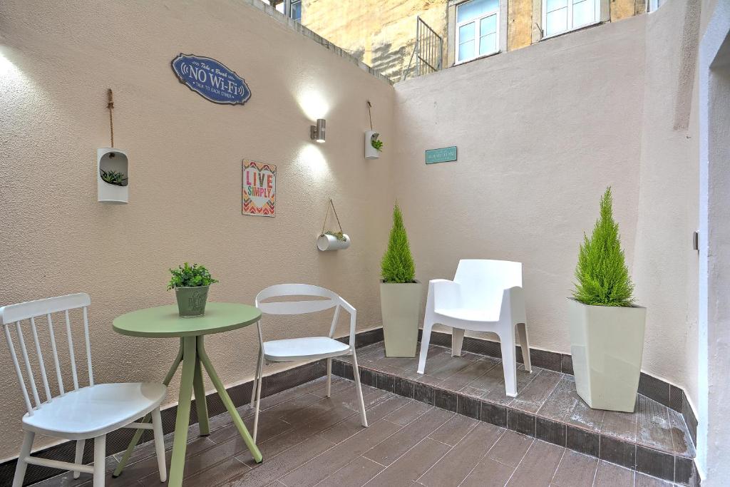 einen Tisch und Stühle auf einer Terrasse in der Unterkunft Traditional Apartment with a Terrace, AC and Fast Internet in Lissabon