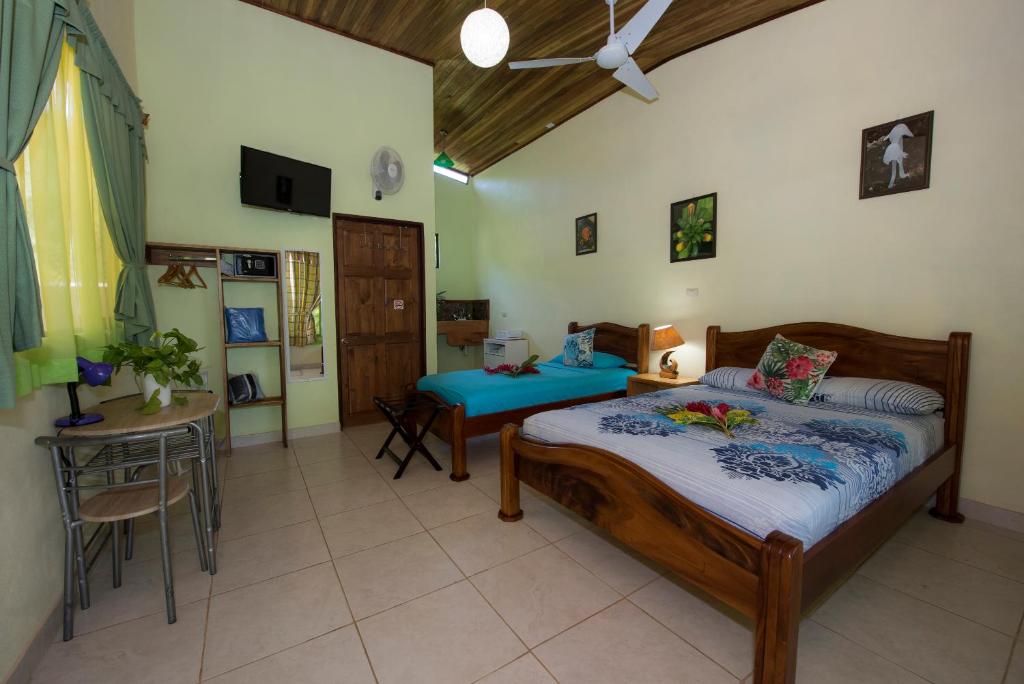 a bedroom with a bed and a table in it at Hotel Sunshine Caribe in Puerto Viejo