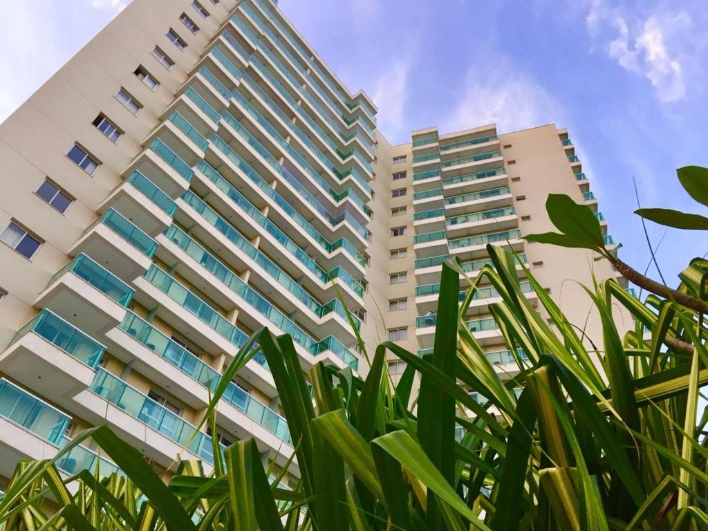 a tall building with some green plants in front of it at RioStay Residence, Riocentro in Rio de Janeiro