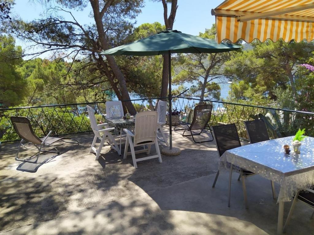 une terrasse avec une table, des chaises et un parasol dans l'établissement Holiday home Vlasta - near sea, à Primošten