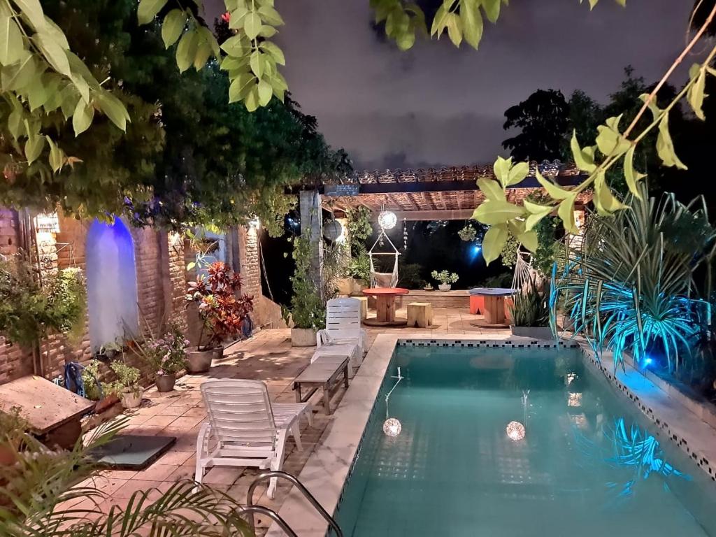 a swimming pool in a backyard with chairs and a table at Hostel e Pousada da 13 Olinda in Olinda