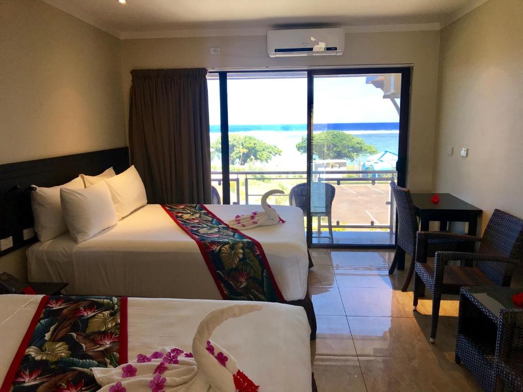 YanduaにあるYadua Bay Resort & Villasのベッド2台が備わる海の景色を望むホテルルームです。