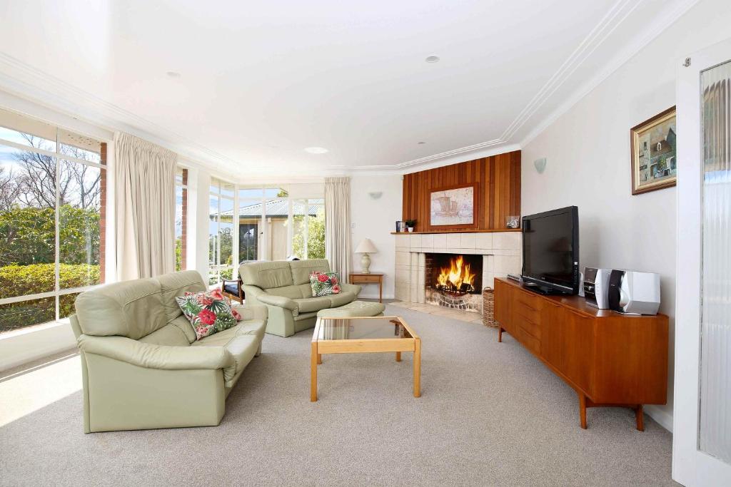 a living room with a tv and a fireplace at Scarlett's Place in Blackheath