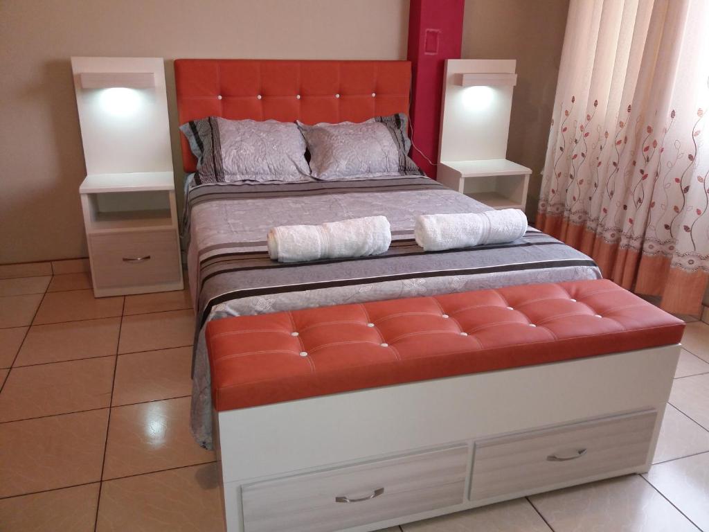 a bedroom with a large bed with an orange headboard at La Quilla House in Lima