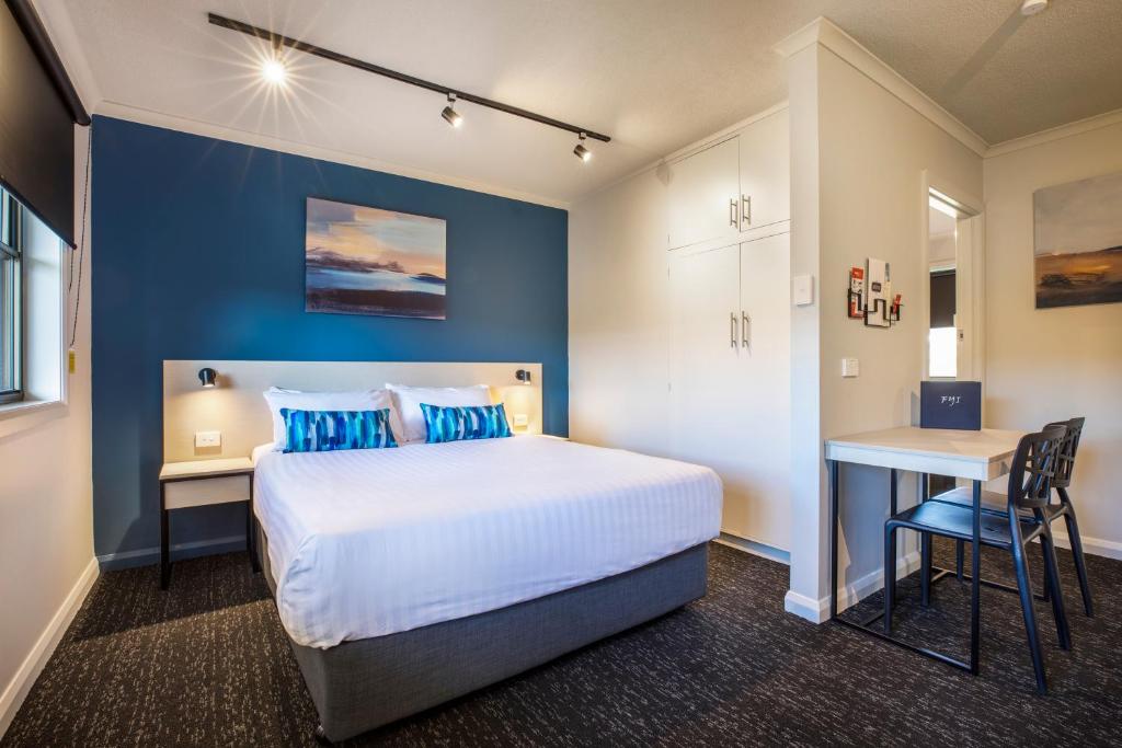 1 dormitorio con 1 cama extragrande y escritorio en Nightcap at Riverside Hotel en Launceston