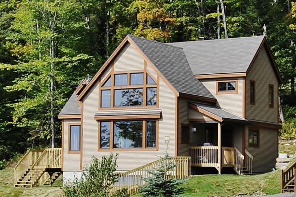 a house with a gambrel roof at 36- Chalet à louer à Stoneham in Stoneham