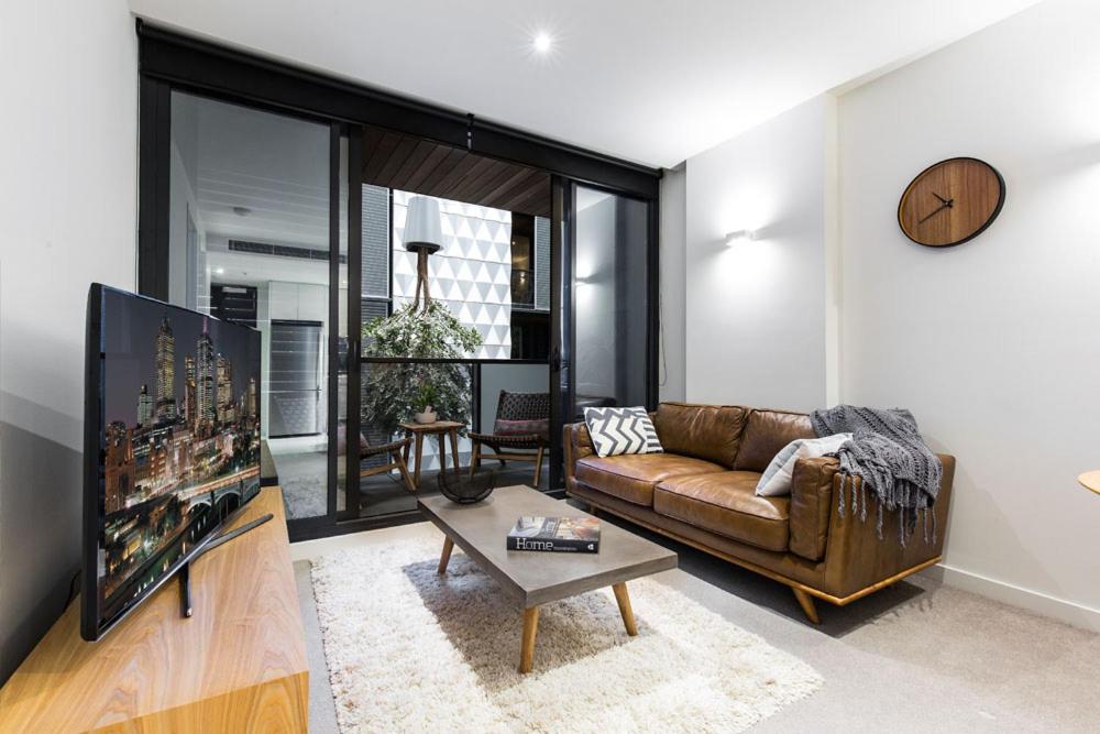 a living room with a couch and a tv at Boutique Abode 313 in Melbourne