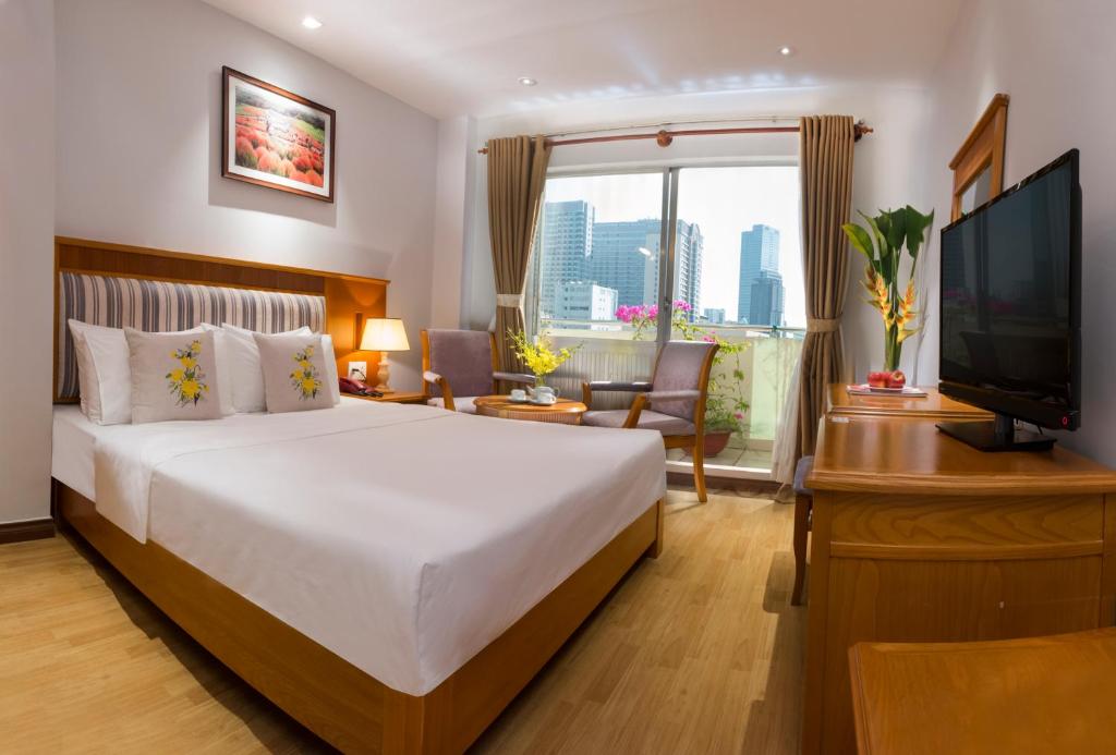 Habitación de hotel con cama y TV en Cherry Central Hotel- Near Opera House, en Ho Chi Minh