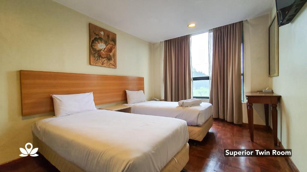 ein Hotelzimmer mit 2 Betten und einem Fenster in der Unterkunft SCC Hotel in Kuala Lumpur