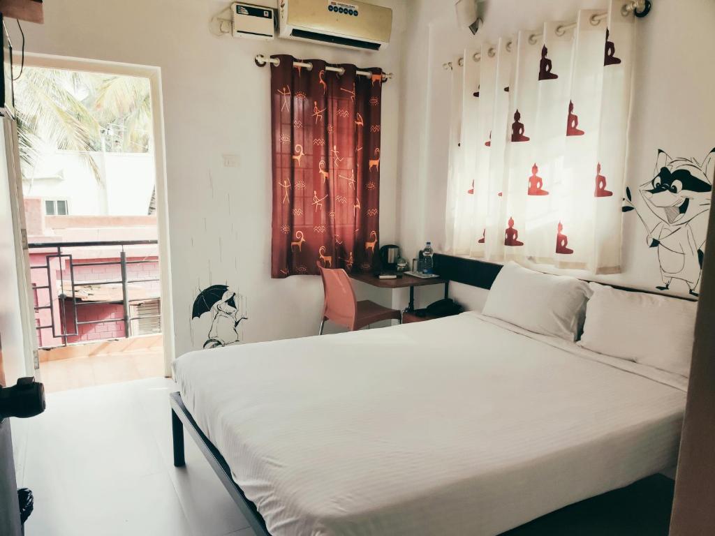 Schlafzimmer mit einem Bett und einem Fenster in der Unterkunft Raccoon Rooms in Mysore