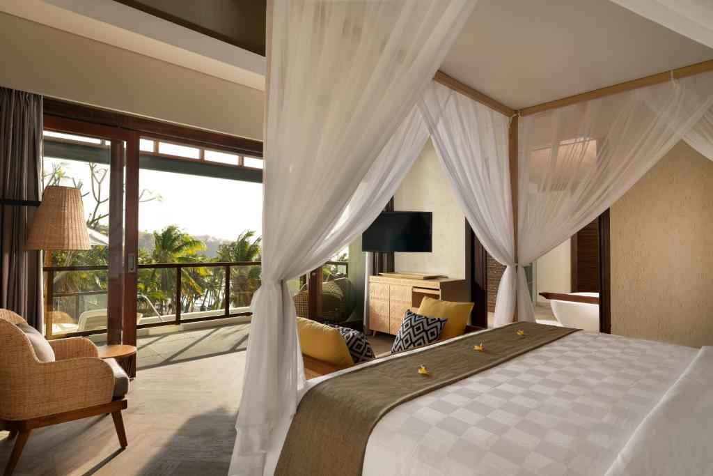 A bed or beds in a room at The Kayana Beach Lombok