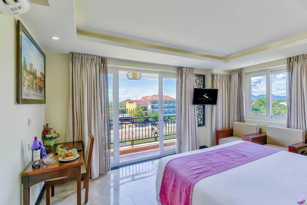 Postel nebo postele na pokoji v ubytování River Suites Hoi An