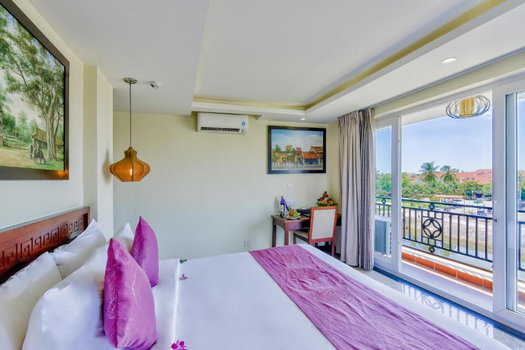 Postel nebo postele na pokoji v ubytování River Suites Hoi An