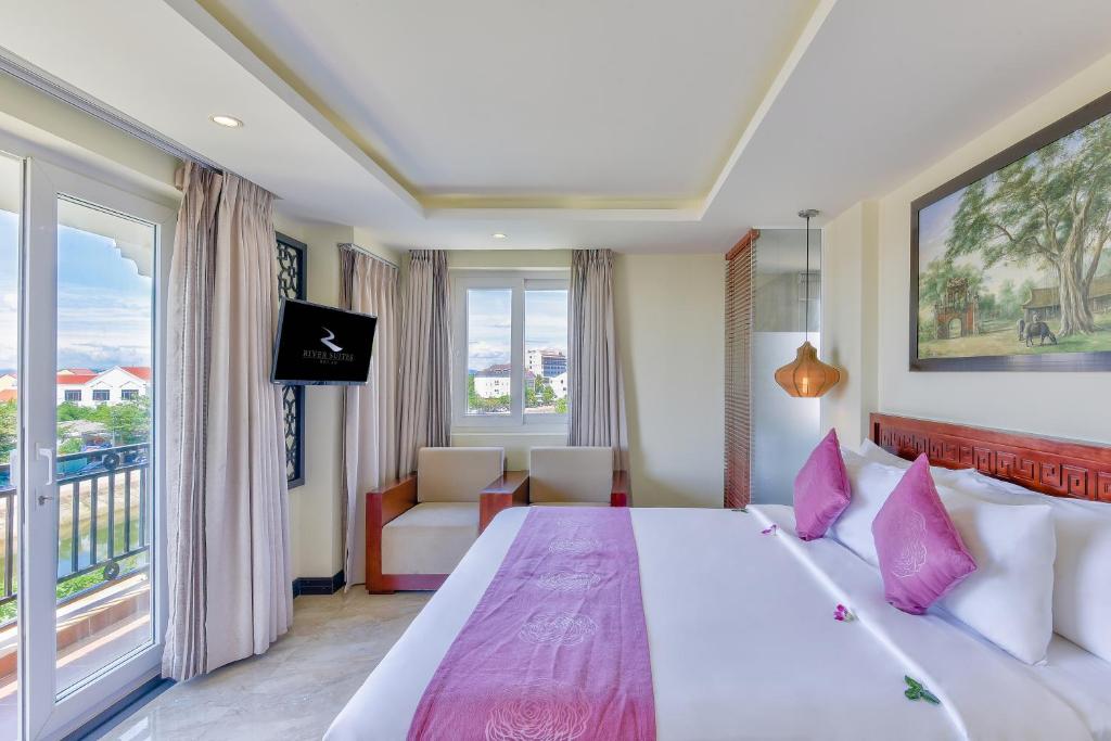 Postel nebo postele na pokoji v ubytování River Suites Hoi An