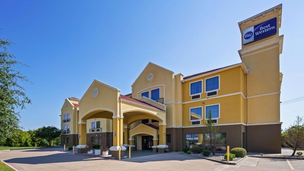 a large yellow building with a sign on it at Best Western Executive Inn Corsicana in Corsicana