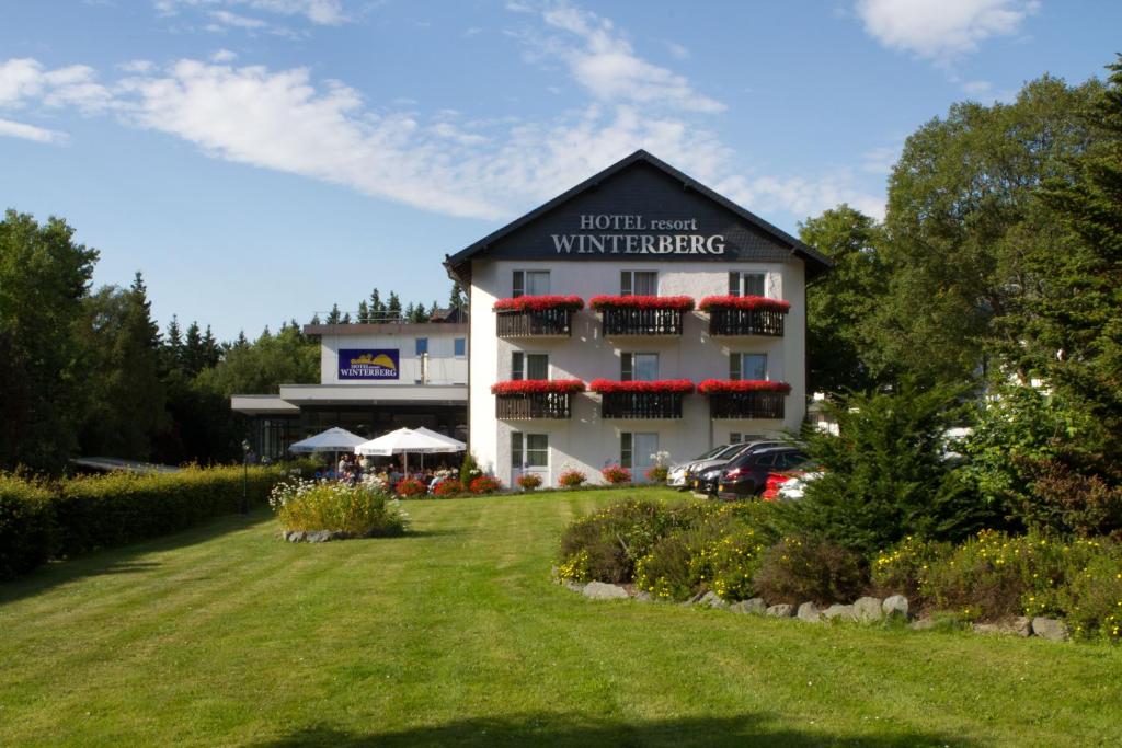 a hotel next to a yard with a building at Hotel Winterberg Resort in Winterberg